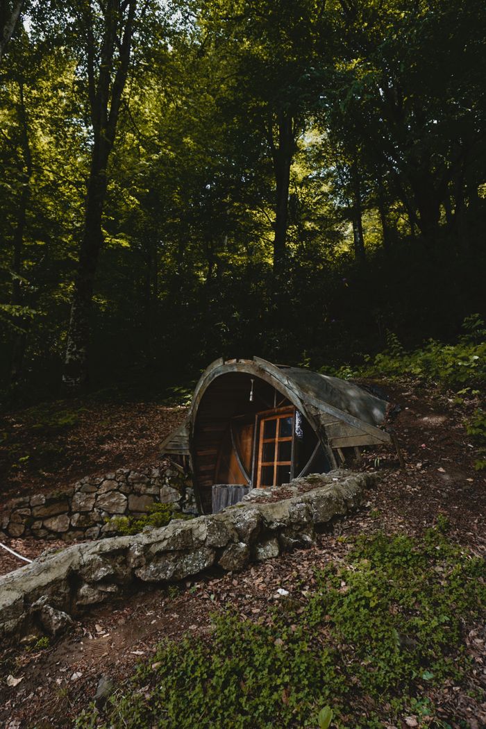 A secluded underground cabin nestled in a lush forest setting.